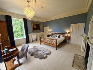 1 dormitorio con cama y lámpara de araña en Sloley Hall, en Tunstead
