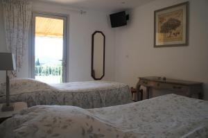a hotel room with two beds and a window at La Bergerie in Joucas