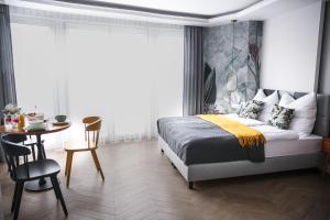 a bedroom with a bed and a table and a dining room at Zielony Dom in Mielno
