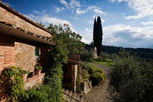 un edificio de ladrillo con plantas al lado de una carretera en Villa Rosano, en Greve in Chianti
