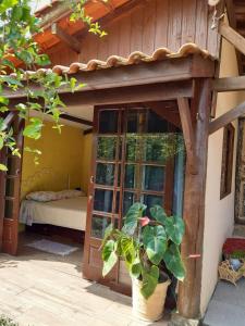 Habitación con puerta, cama y planta en Hibisco Rosa Aluguéis en Araçatuba