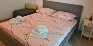 a bed with pink sheets and towels on it at Apartmants Bubalo in Trpanj