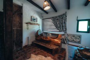 a living room with a wooden chair and a window at Porumbacu Mountain Views - Cabană cu Piscină in Porumbacu de Sus +24 photos