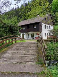 un puente de madera que conduce a una casa con un edificio en pension TARA en Teplice nad Metují