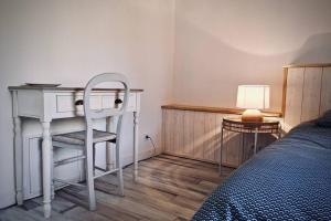1 dormitorio con escritorio, 1 cama y 1 silla en Gîte indépendant dans villa entre mer et maquis, en Sisco
