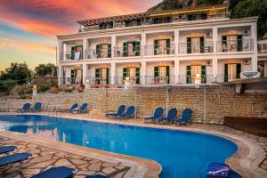 a hotel with a swimming pool in front of a building at Fotini Studios in Paleokastritsa