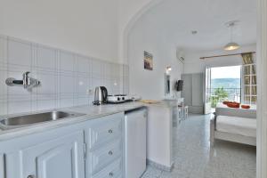 a white kitchen with a sink and a counter at Fotini Studios in Paleokastritsa