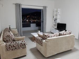 een woonkamer met 2 banken en een televisie bij Bill's Apartments in Sarandë