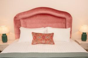 a bed with a red headboard and a pillow on it at Springkell in Eaglesfield
