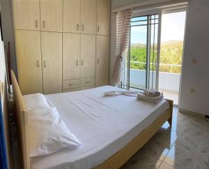 a bedroom with a large bed and a large window at Villa George in Apolakkiá