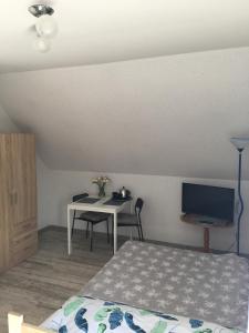 a bedroom with a bed and a table with a television at U Wróbelka in Grzybowo