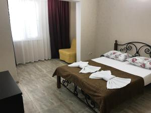 una habitación de hotel con 2 camas y una silla en Zhasmin Guest House, en Loo