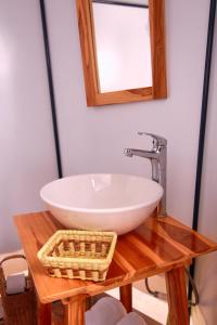 y baño con lavabo y espejo sobre una mesa de madera. en La Cabaña Glamping Geronimo, en Playa Blanca