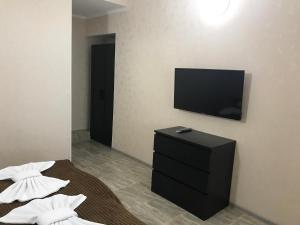 1 dormitorio con TV y 1 cama con almohadas en Zhasmin Guest House, en Loo