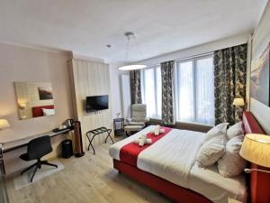 a hotel room with a large bed and a desk at Hotel Cardiff in Ostend