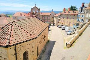 a view of a town with cars parked on a street at Gîte de la chapelle, au coeur de la cité médiévale in Allègre