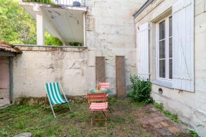 duas cadeiras e uma mesa sentadas fora de um edifício em Little GAMBETTA em Saumur