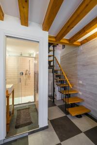 a bathroom with a walk in shower and a staircase at Night Galleria - bed & art in Burano