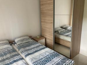 - 2 lits dans une petite chambre avec un miroir dans l'établissement Apartament 8, à Pobierowo
