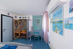 a bedroom with a table and a blue floor at Night Galleria - bed & art in Burano