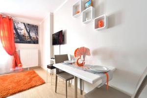 een eetkamer met een witte tafel en stoelen bij Orange Studio Paris Disneyland in Serris