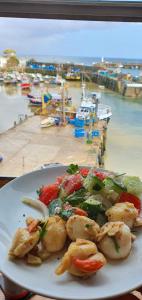 a plate of food on a table next to a marina at Harbour Tavern Penthouse in Mevagissey