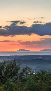 un tramonto su un campo con alberi e nuvole di B&B CASA MARTINA a Giungano