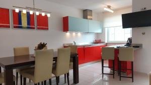 a kitchen with red cabinets and a table and chairs at Royal Appartements Sölden in Sölden