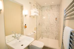 a bathroom with a sink and a toilet and a shower at Springkell in Eaglesfield