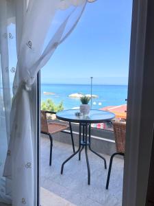 un tavolo su un balcone con vista sull'oceano di M&N Apartments a Archangelos