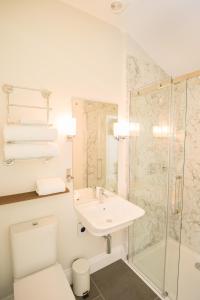 a bathroom with a toilet and a sink and a shower at Springkell in Eaglesfield