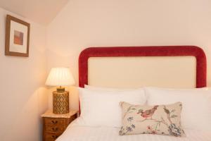 a bedroom with a white bed and a lamp at Springkell in Eaglesfield
