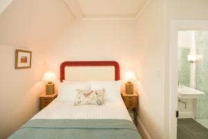 a bedroom with a bed and two lamps and a sink at Springkell in Eaglesfield