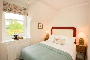 a bedroom with a bed and a window at Springkell in Eaglesfield