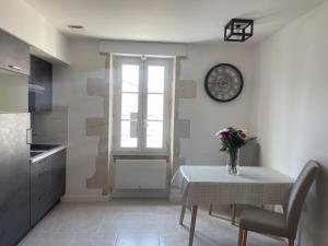 a kitchen with a table and a clock on the wall at Bâbord in La Flotte