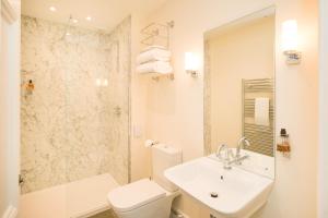a bathroom with a sink and a toilet and a shower at Springkell in Eaglesfield