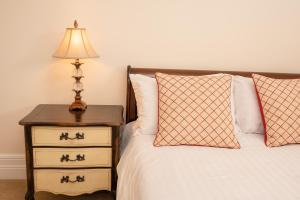 a bed with a nightstand with a lamp and two pillows at Springkell in Eaglesfield