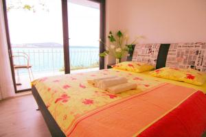 a bed in a room with a large window at Apartments Marta in Trogir
