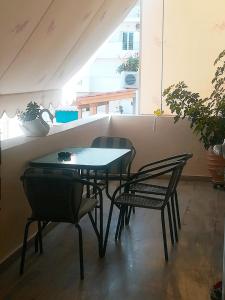 einen Tisch und Stühle in einem Zimmer mit Fenster in der Unterkunft Amazing Apartment next to the sea! in Agios Nikolaos