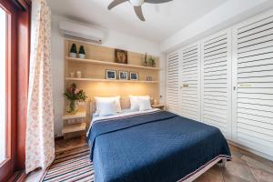 Schlafzimmer mit einem blauen Bett und weißen Kissen in der Unterkunft villa Bellavista in Torre delle Stelle