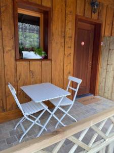 uma mesa e duas cadeiras sentadas ao lado de uma janela em Gîte Little Creek em Hamoir