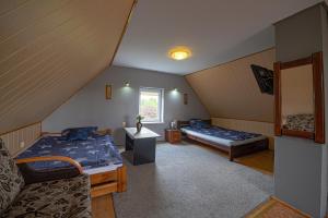 Zimmer im Dachgeschoss mit 2 Betten und einem Sofa in der Unterkunft Pensjonat Jagoda in Pisz