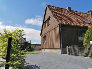 uma casa castanha com um telhado vermelho e uma entrada em Harzhaus Ida em Elbingerode