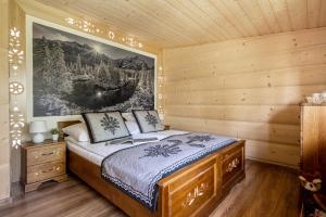 ein Schlafzimmer mit einem Bett in einer Holzhütte in der Unterkunft Apartamenty Anna Maria-Chochołów in Chochołów