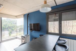 a conference room with a table and chairs and windows at Apartamentos Cubicos in Bronchales