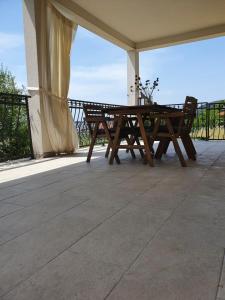 un tavolo da picnic in legno sul portico di una casa di Villa Malena a Rab