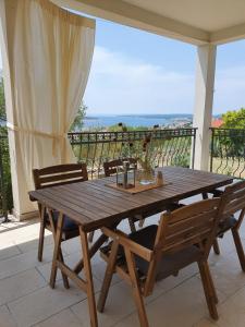 una mesa de madera y sillas en un patio con vistas en Villa Malena en Rab