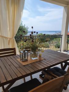 a wooden table on a balcony with a view of the ocean at Villa Malena in Rab