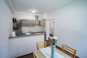 a kitchen and dining room with a table and chairs at Apartments Šentvid in Ljubljana