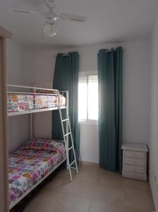 1 dormitorio con litera y escalera en Dunas de punta candor, en Rota